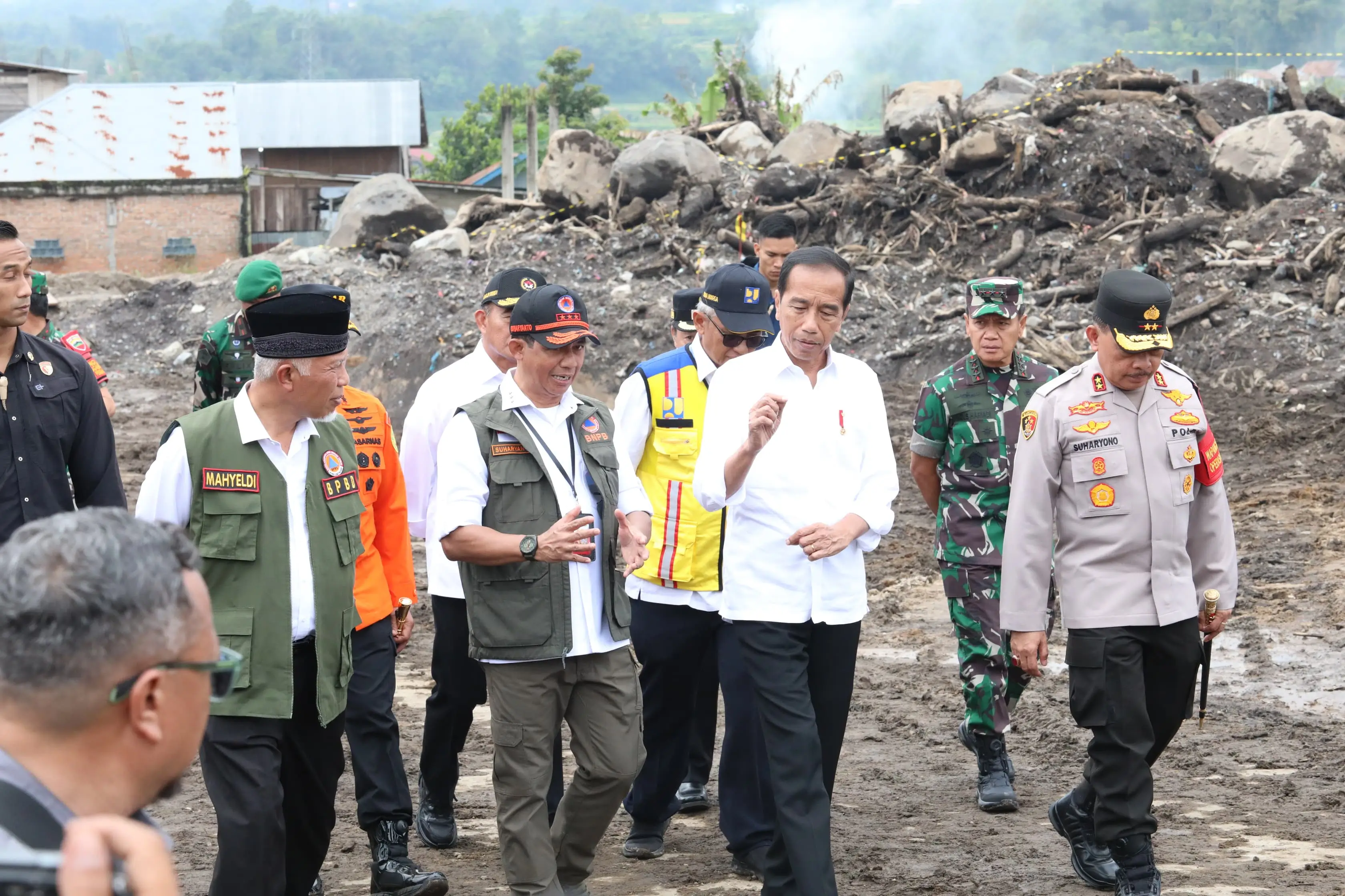 Kepala BNPB Letjen TNI Suharyanto, S.Sos., M.M., (rompi hijau dengan topi hitam) berdiskusi dengan Presiden Ir. Joko Widodo saat meninjau lokasi terdampak banjir lahar hujan Gunungapi Marapi di Nagari Bukit Batabuah, Kabupaten Agam, Sumatera Barat pada Selasa (21/5).